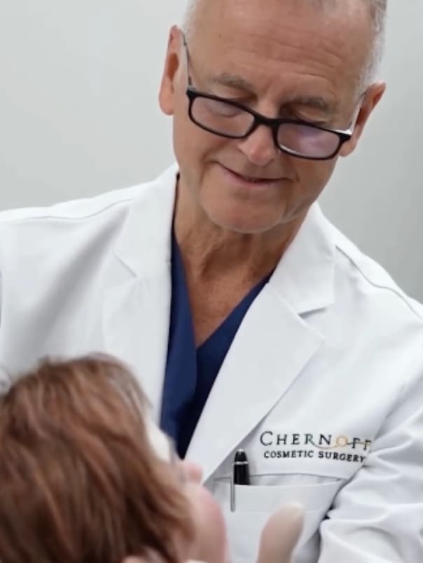 Dr.Chernoff examines a patient's face. There is a major difference between just being a surgeon, and being a pioneer in the aesthetics industry