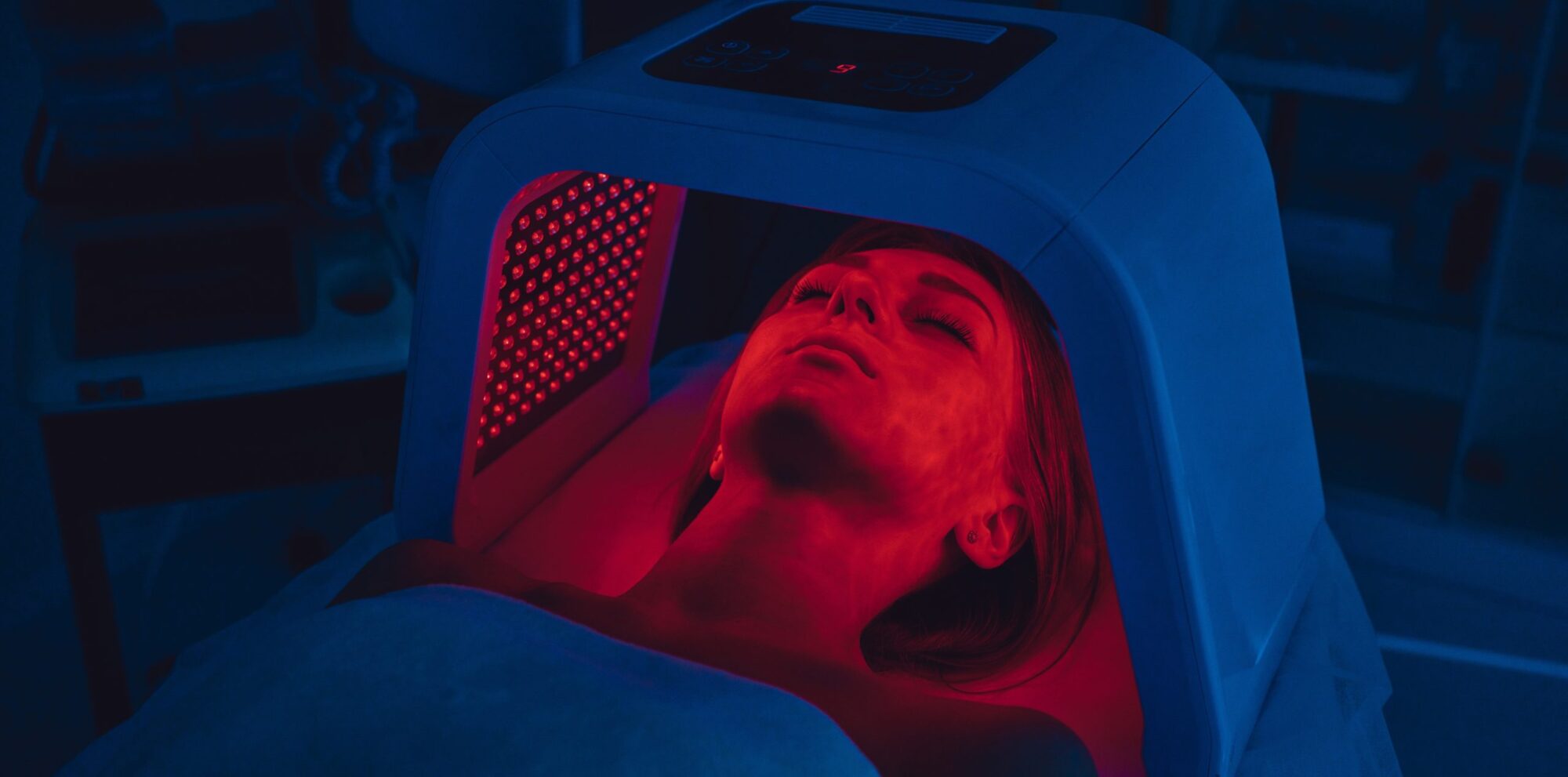 LED red light is treating the facial skin of a young woman. High quality 4k footage